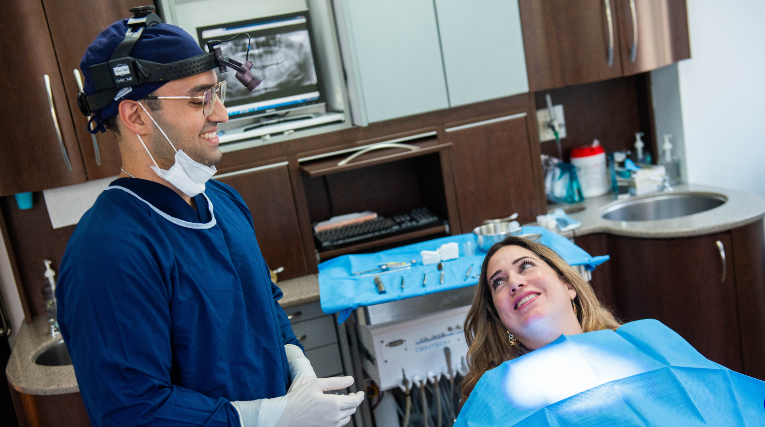 An oral and maxillofacial surgeon at Seaforth Oral Surgery in Montreal with a smiling dental implant patient 