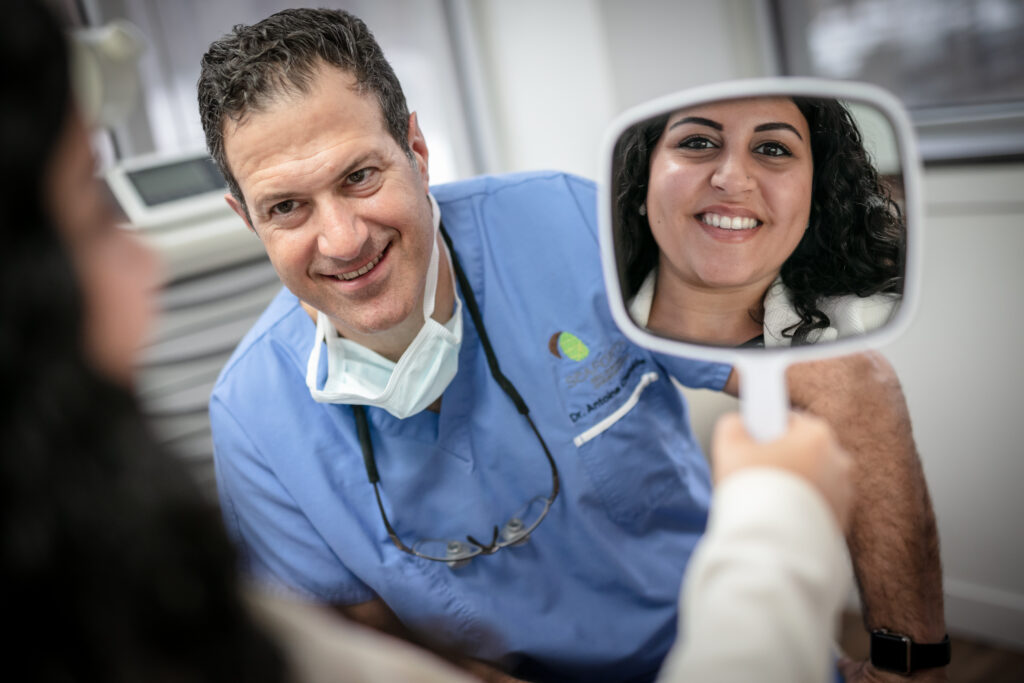 A patient smiling with her newly placed dental implant.