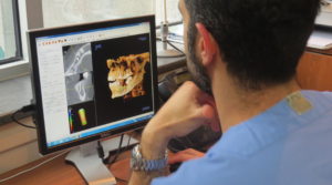 Oral surgeon explaining the differences between a dental implant and a dental bridge during a consultation in Montreal.