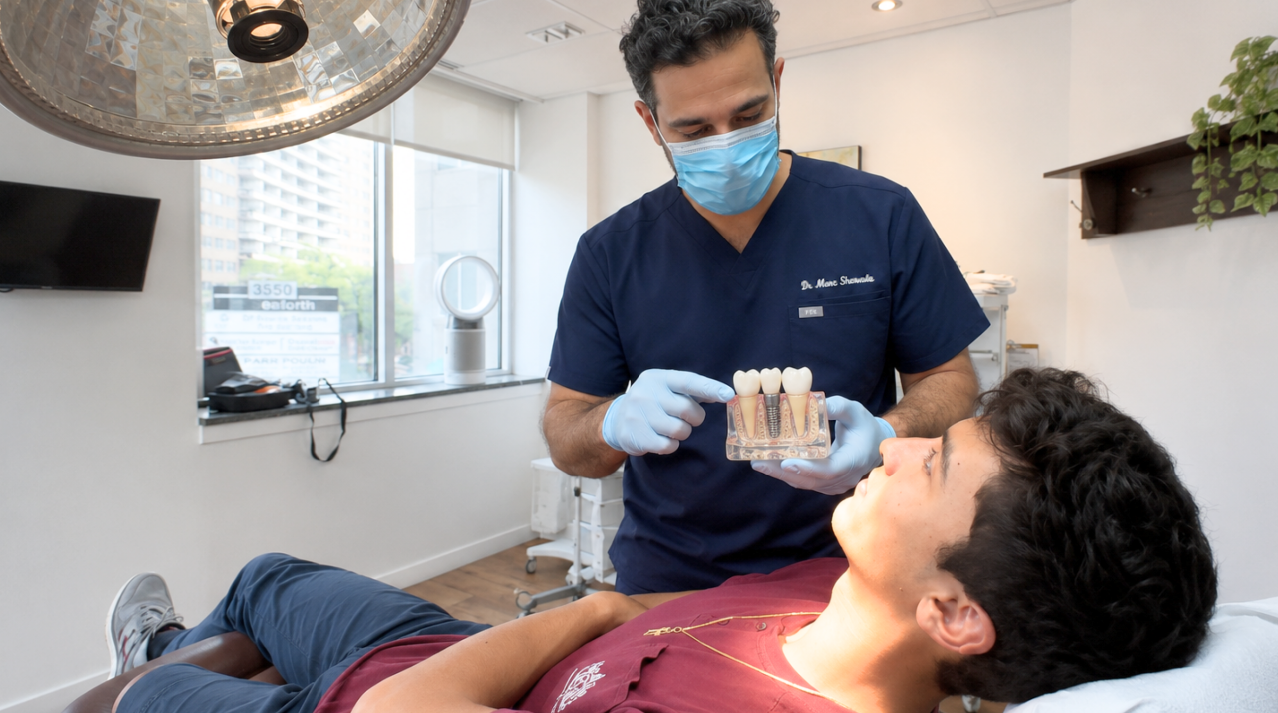Oral surgeon evaluating a patient before dental implant treatment.