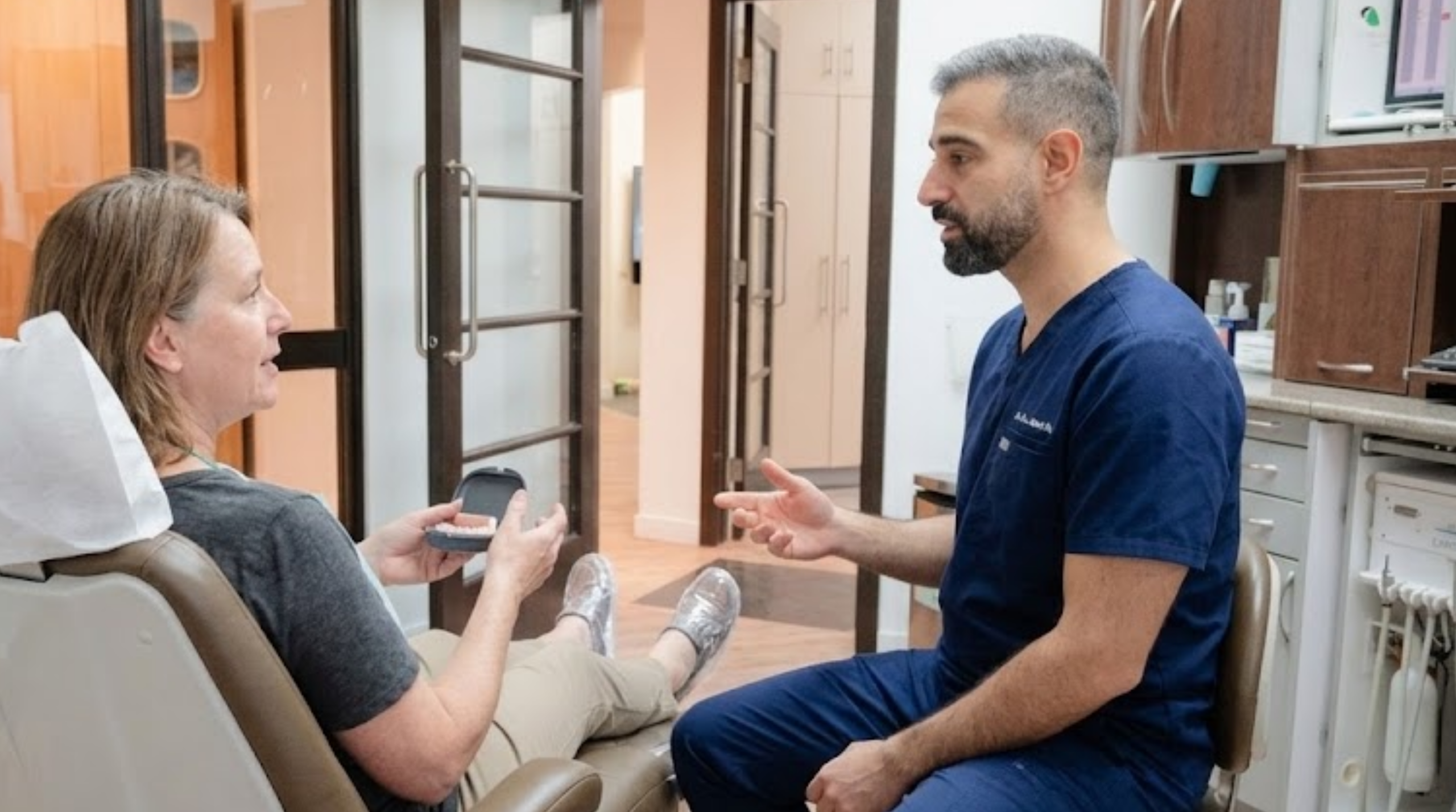 Patient discussing alternatives to traditional dentures with an oral surgeon.