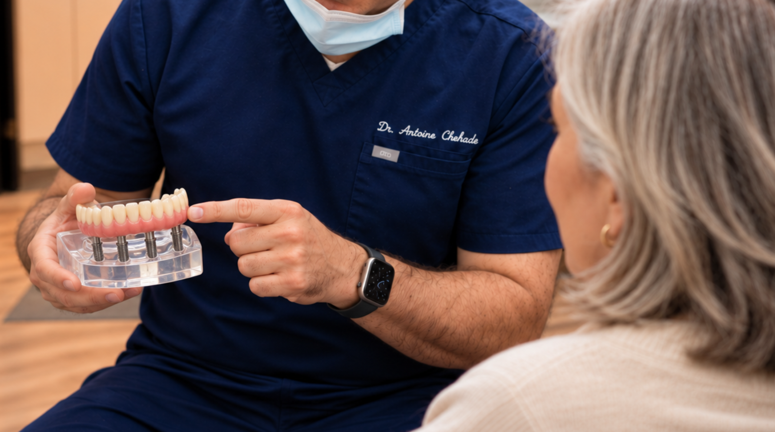 Patient reviewing full-arch dental implant options with an oral surgeon. 