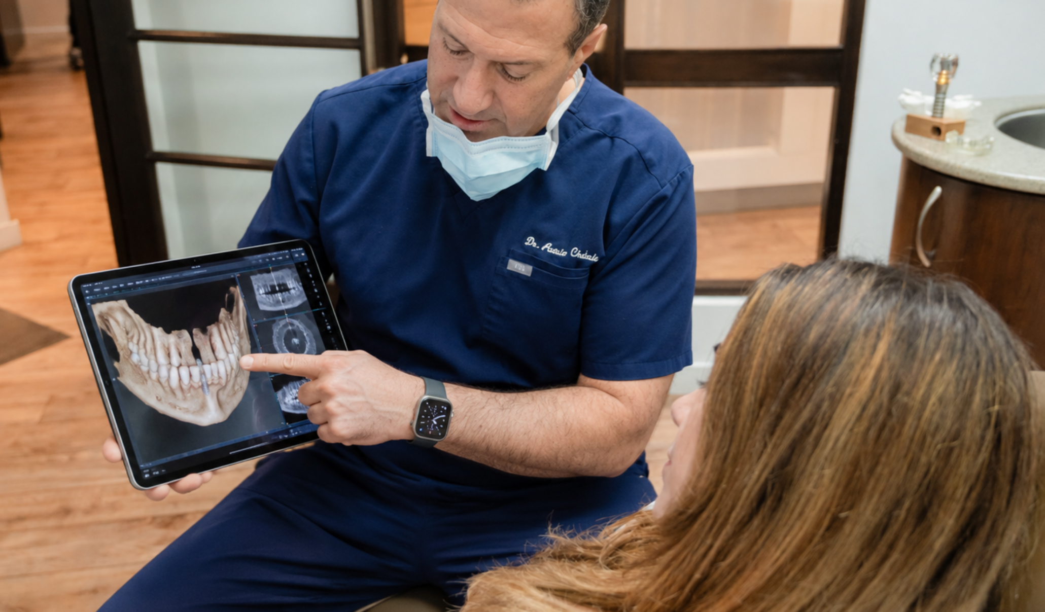 Clinician reviewing 3D jaw imaging for missing-tooth replacement planning.